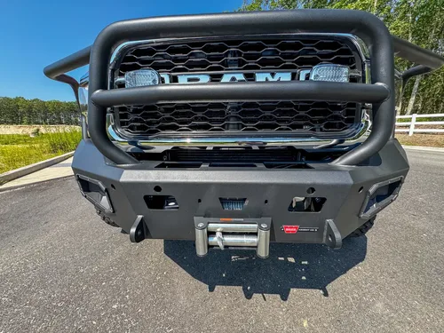 Front bumper close-up with winch mount opening and tow/recovery points.